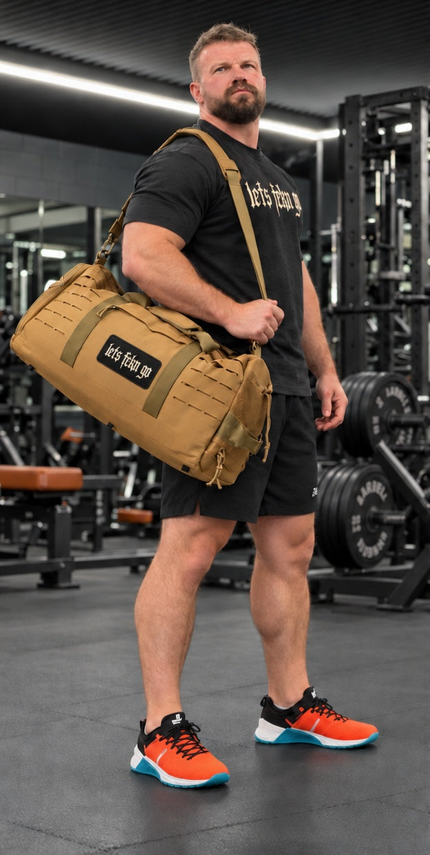 Jake with tan duffel bag and LETS FCKN GO Velcro patch in the gym